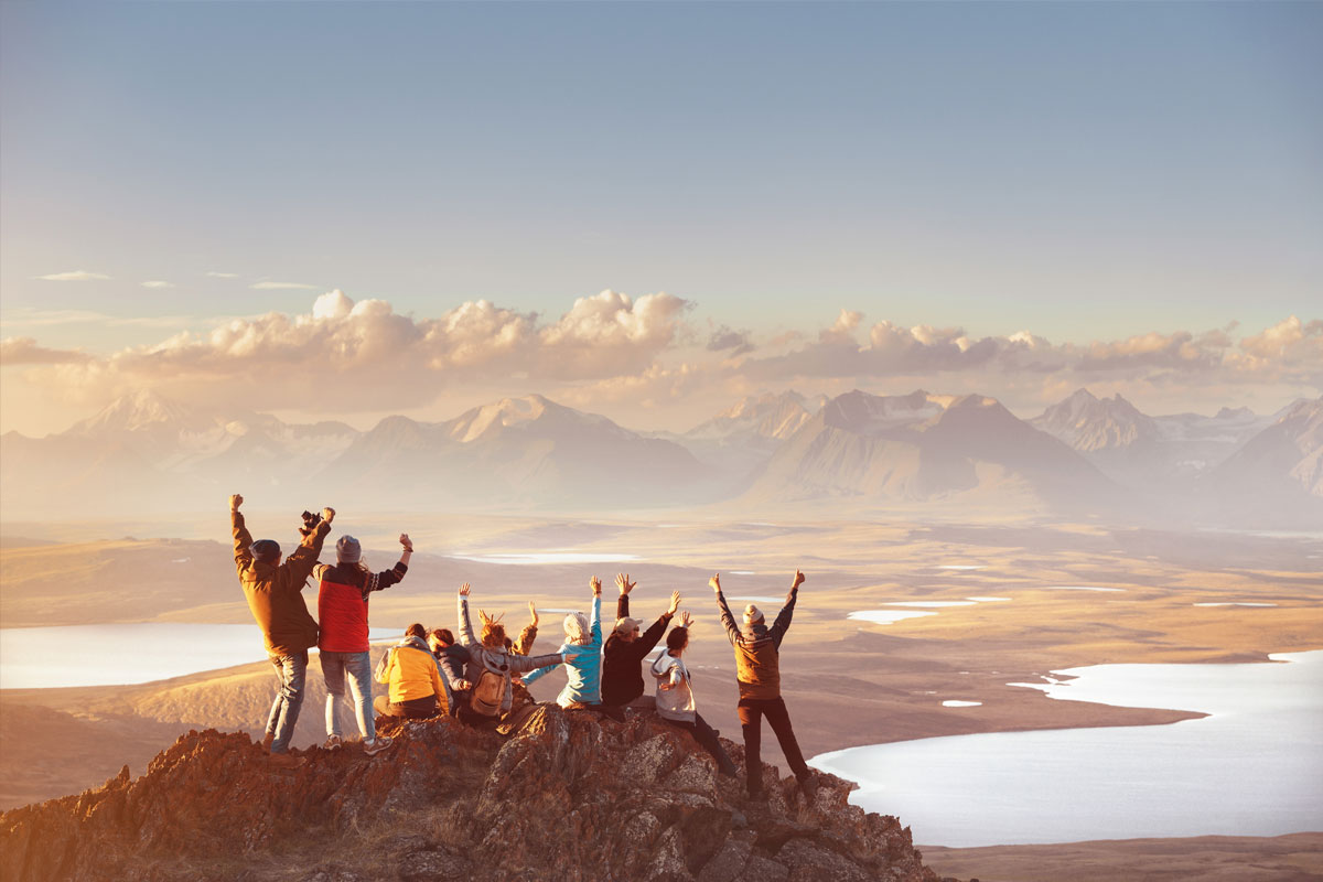 Reisegruppe auf Berggipfel mit atemberaubendem Ausblick